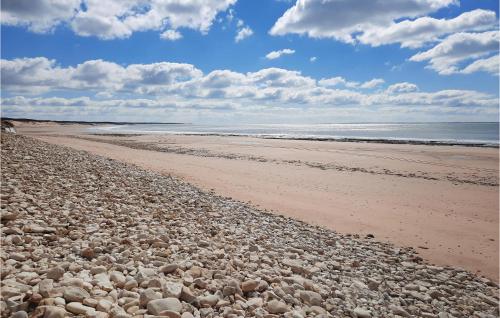 une plage avec des rochers et l'océan par temps nuageux dans l'établissement Beautiful Home In Longeville-Sur-Mer, à Longeville-sur-Mer