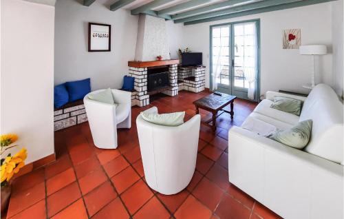 Elle comprend un salon doté d'un mobilier blanc et d'une cheminée. dans l'établissement Beautiful Home In Longeville-Sur-Mer, à Longeville-sur-Mer
