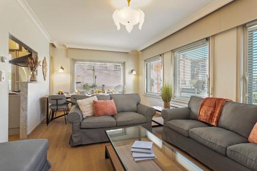 a living room with two couches and a table at Maison Emile in De Panne