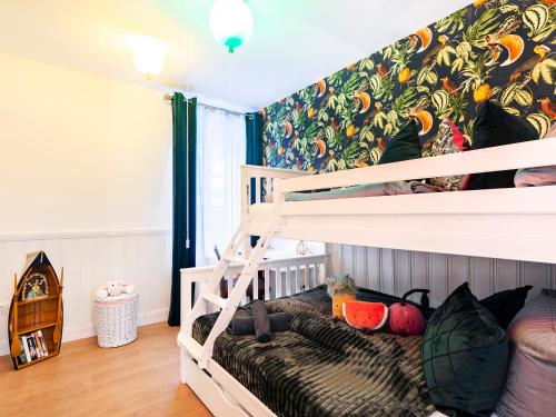 a bedroom with two bunk beds with a tropical wallpaper at Ostseeresidenz Lidia mit Terrasse und Meerblick in Sassnitz