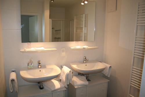 uma casa de banho com 2 lavatórios, um espelho e toalhas em Am Finkenbusch aan de skipiste em Willingen