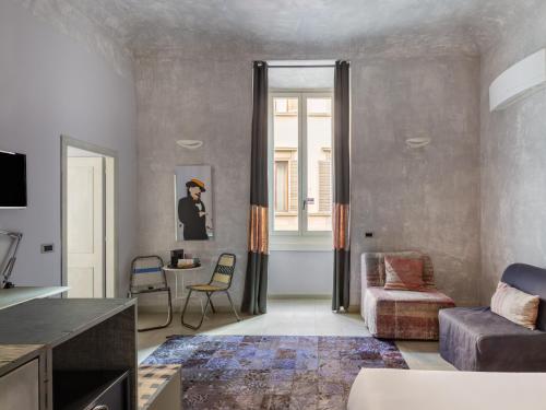 a living room with a couch and a chair at numa l Rodo Rooms & Apartments in Florence