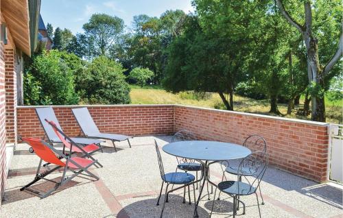 a patio with tables and chairs and a brick wall at 2 Bedroom Stunning Home In Roisel in Roisel