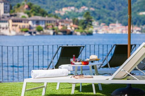 a table with a bowl of fruit on it next to a lake at Bifora65 flats and garden - Lakeview in Orta San Giulio