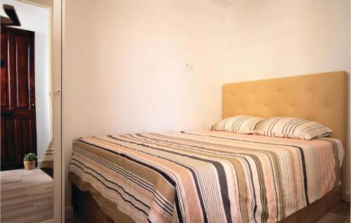 um quarto com uma cama com um cobertor listrado em Beautiful Apartment In Torrevieja With Kitchenette em La Mata