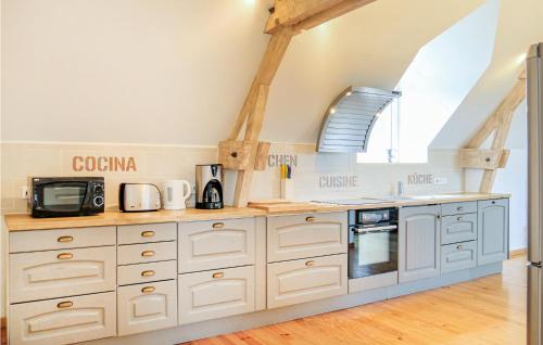 a kitchen with white cabinets and a vaulted ceiling at 2 Bedroom Amazing Apartment In Ponts in Ponts