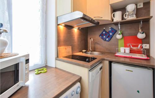 une petite cuisine avec un évier et une cuisinière dans l'établissement Gorgeous Apartment In Arromanches, à Arromanches-les-Bains