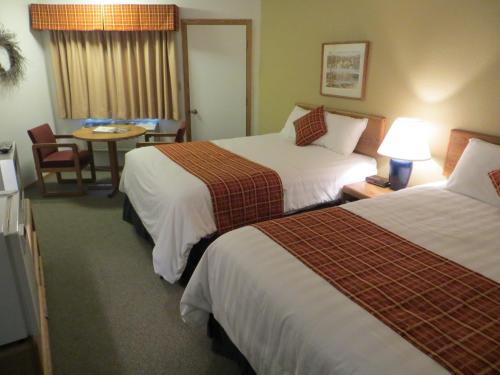 a hotel room with two beds and a table at The Nordic Lodge in Sister Bay