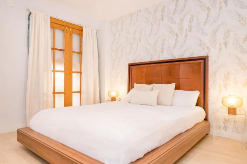 1 dormitorio con 1 cama blanca grande y 2 lámparas en BHost - The Special One, en Málaga