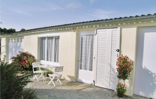 une maison avec une terrasse, une table et des chaises dans l'établissement Amazing Home In Quettehou, à Quettehou