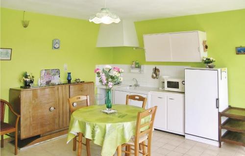 a kitchen with a table with a vase of flowers on it at Amazing Home In Quettehou in Quettehou