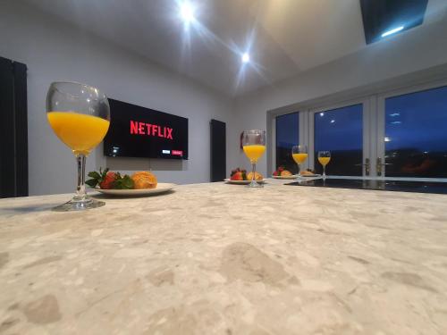 three glasses of wine sitting on a counter in a room at 4 BR Luxury House. Bike Park Wales. Secure Bike Store. Brecon Beacons in Dowlais