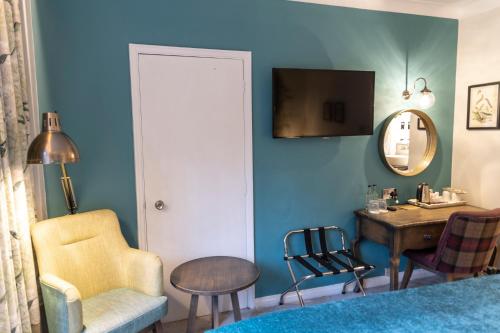 a room with a table and a chair and a mirror at The Stanneylands in Wilmslow