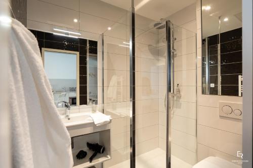 een witte badkamer met een douche en een wastafel bij Activinum in Givry