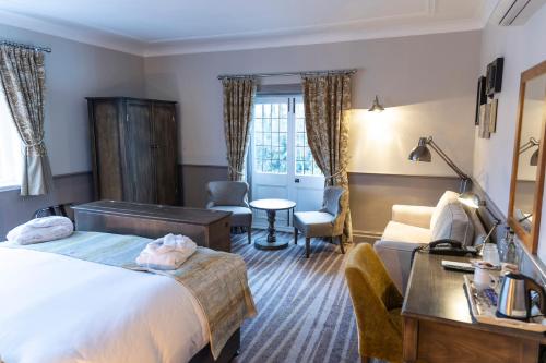 a hotel room with a bed and a desk at The Stanneylands in Wilmslow