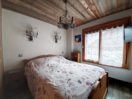 een slaapkamer met een bed en een kroonluchter bij Appartement Favre 73 in Moutiers