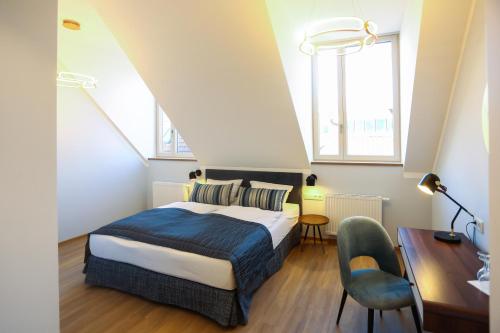 a bedroom with a bed and a desk and two windows at Hotel Lutz in Rain