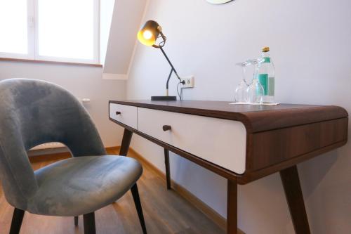 a desk with a chair and a lamp on it at Hotel Lutz in Rain