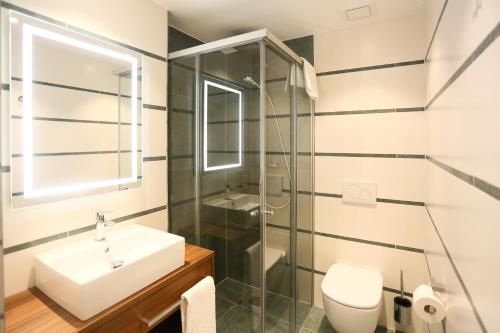 a bathroom with a sink toilet and a shower at Hotel Lutz in Rain