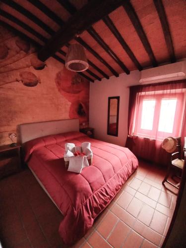 a bedroom with a red bed with two boxes on it at Poppy's House in Casole dʼElsa