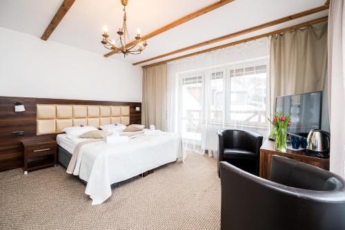 ein Hotelzimmer mit 2 Betten und einem TV in der Unterkunft Hotel Ariston in Karpacz