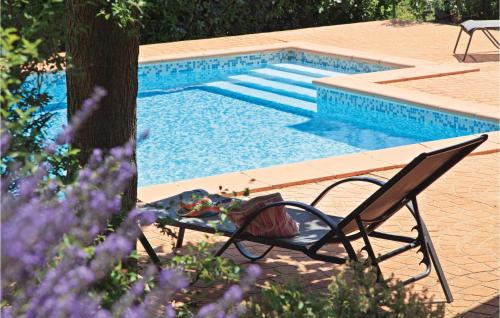 a table and a chair next to a swimming pool at 4 Bedroom Awesome Home In Roquebrun in Roquebrun