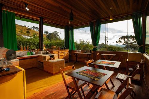 a living room with a table and chairs and a kitchen at Hospedaria Estação Píccola No quintal da Pedra do Baú in São Bento do Sapucaí