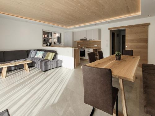 a living room and kitchen with a wooden table at Gästehaus Sonne in Bichlbach