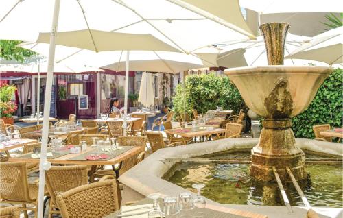 a fountain in a restaurant with tables and umbrellas at Lovely Home In Spéracèdes With Wifi in Spéracèdes