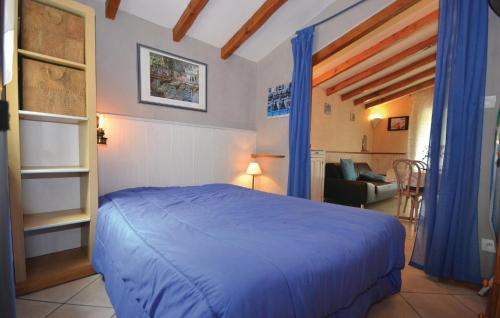 ein Schlafzimmer mit einem blauen Bett und ein Wohnzimmer in der Unterkunft Nice Home In Sarrians With Wifi in Sarrians