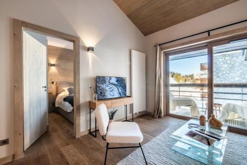 Pokój z sypialnią, łóżkiem i szklanym stołem w obiekcie Residence Phoenix Courchevel Village - by EMERALD STAY w Courchevel