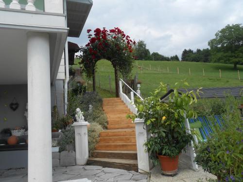 a house with a staircase with red flowers on it at Privatzimmer Haus Gschweitl in Semriach