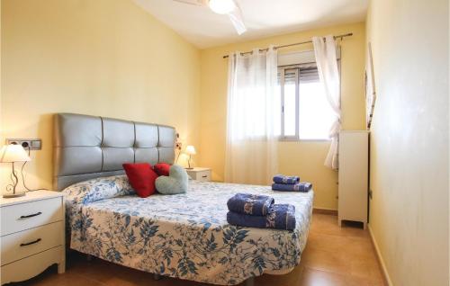 ein Schlafzimmer mit einem Bett mit Kissen darauf in der Unterkunft 3 Bedroom Beautiful Apartment In Los Alczares in Los Alcázares