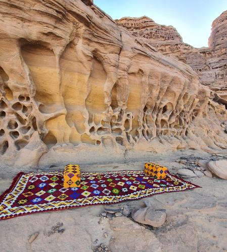 a rug laying on the ground next to a cliff at استراحه كيان in AlUla