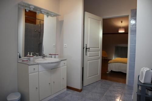a white bathroom with a sink and a mirror at Gîtes & Chambres d'hôtes Peyrecout in Laparrouquial
