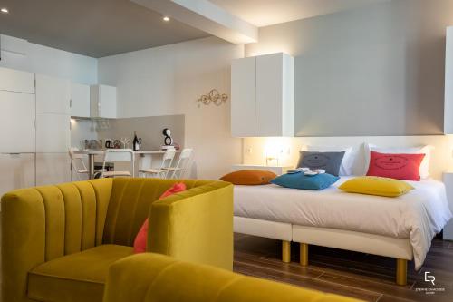 a bedroom with a bed and a yellow couch at Activinum in Givry
