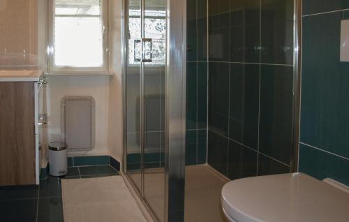 a bathroom with a toilet and a glass shower at Awesome Home In Tredrez-locquemeau With 3 Bedrooms And Wifi in Locquémeau