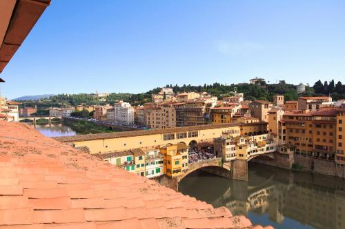 Blick auf eine Stadt mit einer Brücke und einem Fluss in der Unterkunft Portrait Firenze - Lungarno Collection in Florenz