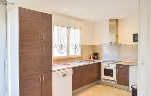 a large kitchen with wooden cabinets and a sink at Les Renoncules Des Champs in Roisel