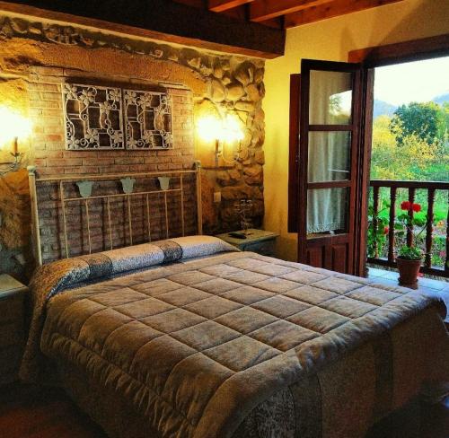 a bedroom with a bed in a room with a window at La Posada de Maria in Villanueva de la Peña