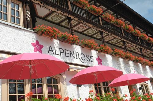 a group of red umbrellas in front of a building at Alpenrose Bayrischzell Hotel in Bayrischzell
