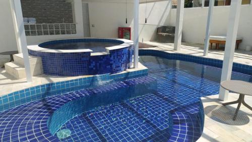 a large swimming pool with a blue tiled floor at WINNER BEACH HOTEL in Juréia