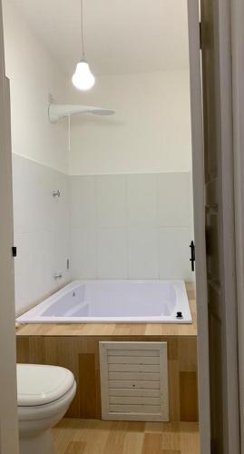 a bathroom with a white tub and a toilet at Aldeia Parque Pousada Rural in São Roque