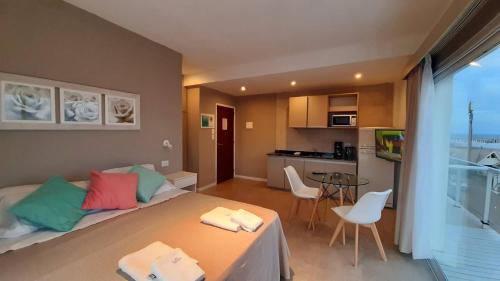 una habitación con una cama y una mesa y una cocina en Los Tritones Apart Hotel de Villa Gesell