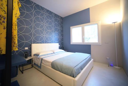 Dormitorio azul con cama y ventana en Nerodavola by PosarelliVillas, en San Corrado di Fuori
