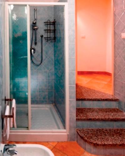 a shower with a glass door next to a sink at Residence Floreal in San Pasquale