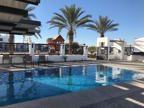a villa with a swimming pool and palm trees at DOLPHIN Maeva Residencial in Puerto Peñasco