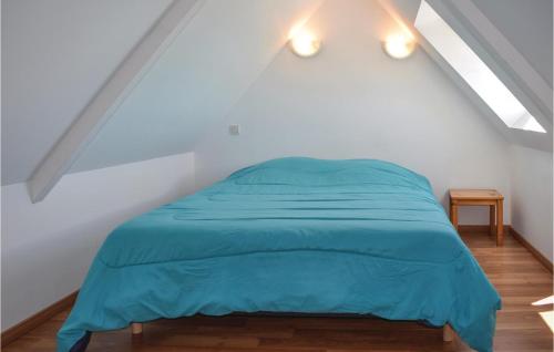 ein Schlafzimmer mit einem blauen Bett im Dachgeschoss in der Unterkunft Gorgeous Apartment In Treguier With Kitchen in Tréguier