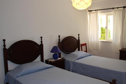 a bedroom with two beds and a lamp and a window at Apartment Casa Azul in Quarteira