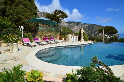 une piscine avec des chaises et un parasol dans l'établissement Luxury Blue Orchid 5BD 5 BATH and beach, à Èze